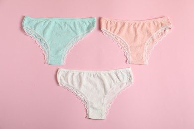 Photo of Women's underwear. Beautiful panties on pink background, flat lay