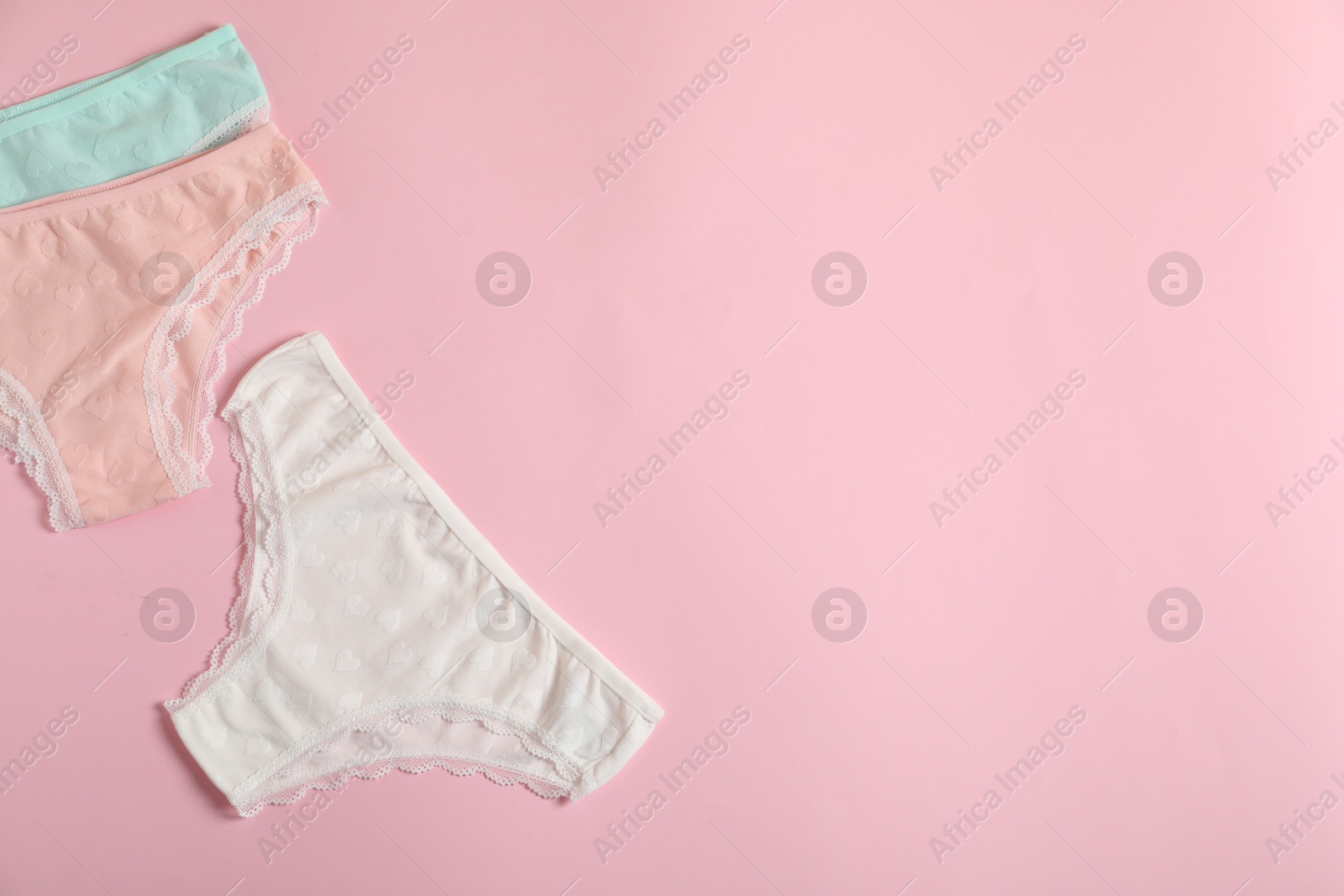 Women's underwear. Beautiful panties on pink background, flat lay. Space for text Photo of Women's underwear. Beautiful panties on pink background, flat lay. Space for text