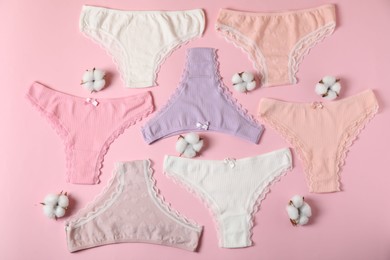 Photo of Women's underwear. Beautiful panties and cotton flowers on pink background, flat lay