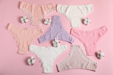 Photo of Women's underwear. Beautiful panties and cotton flowers on pink background, flat lay