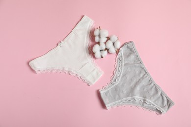 Photo of Women's underwear. Beautiful panties and cotton flowers on pink background, flat lay