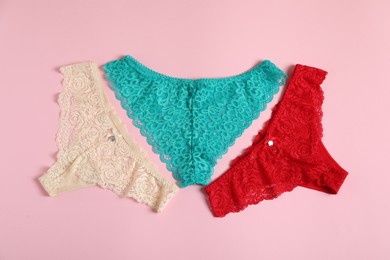 Photo of Women's underwear. Beautiful panties on pink background, flat lay