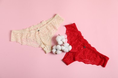 Photo of Women's underwear. Beautiful panties and cotton flowers on pink background, flat lay