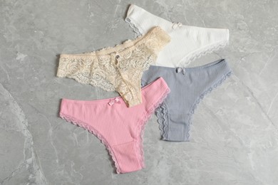 Photo of Women's underwear. Beautiful panties on gray marble background, flat lay