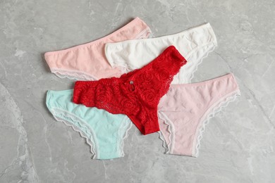 Photo of Women's underwear. Beautiful panties on gray marble background, flat lay