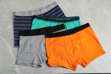 Photo of Comfortable men's underwear on gray marble background, flat lay