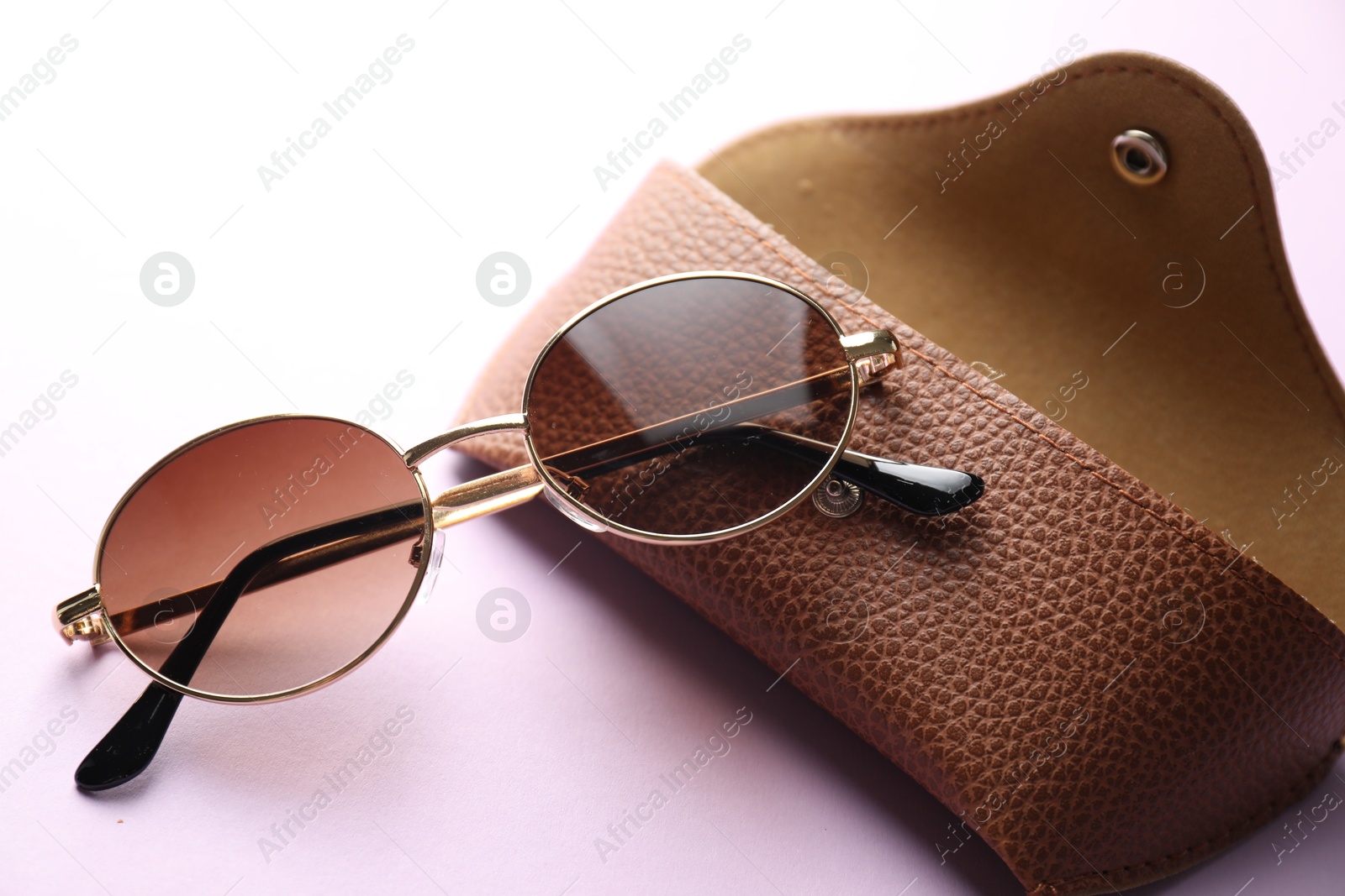Case with stylish glasses on violet background, closeup Photo of Case with stylish glasses on violet background, closeup
