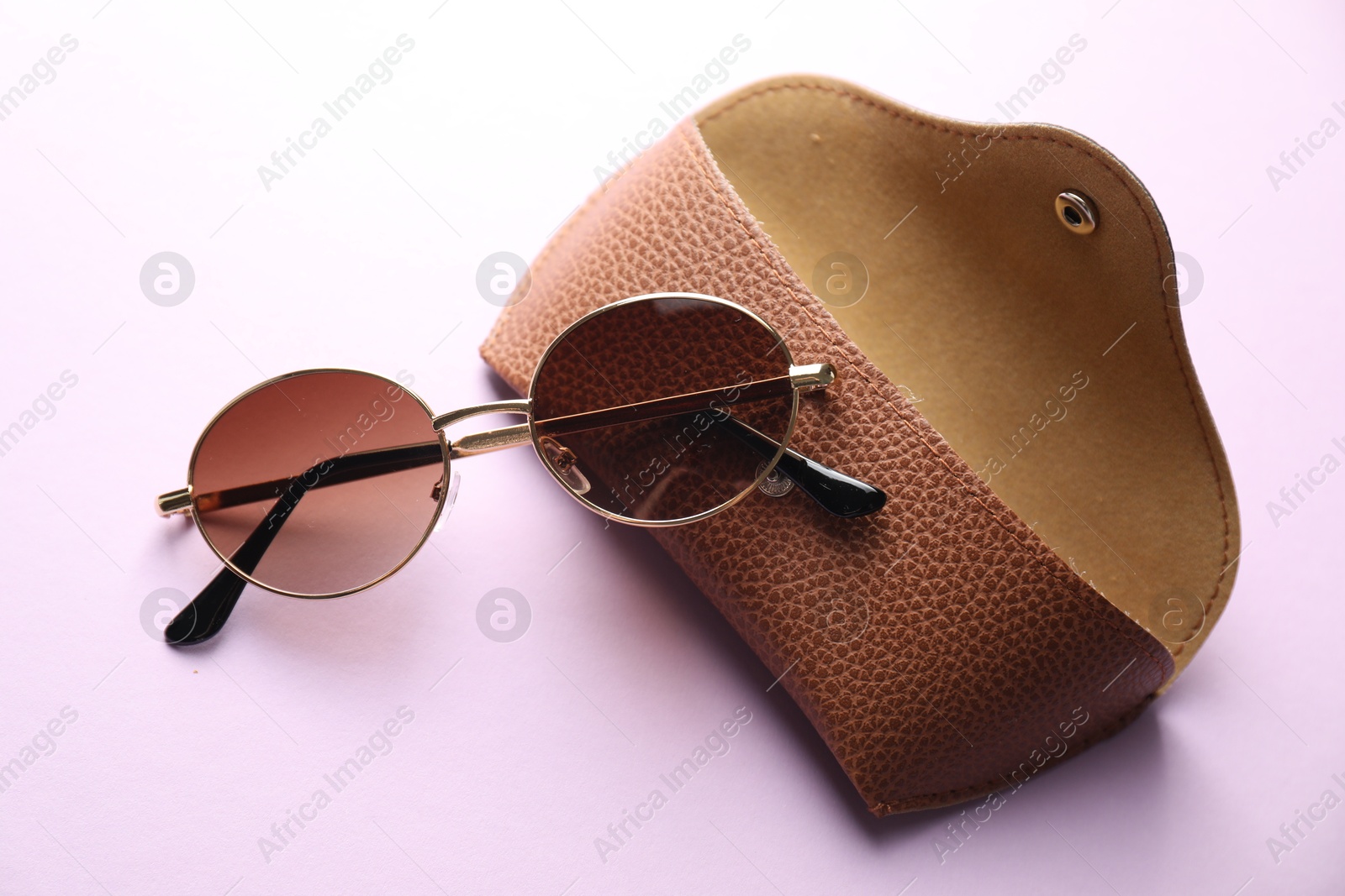 Case with stylish glasses on violet background, flat lay Photo of Case with stylish glasses on violet background, flat lay