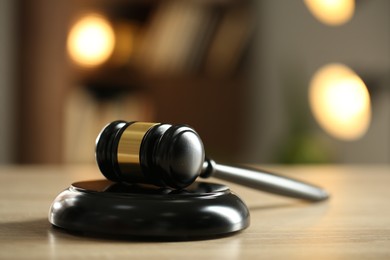 Photo of Judge's gavel on wooden table against blurred background, closeup