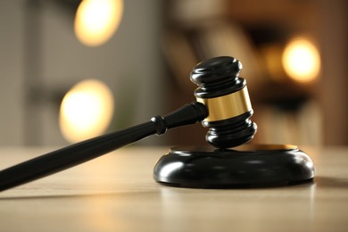 Photo of Judge's gavel on wooden table against blurred background, closeup