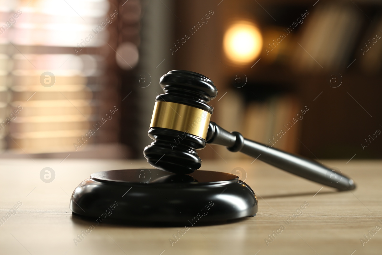 Photo of Judge's gavel on wooden table against blurred background, closeup