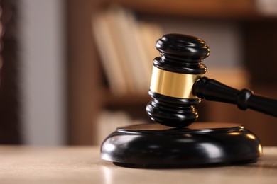 Photo of Judge's gavel on wooden table against blurred background, closeup