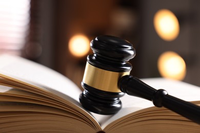 Photo of Judge's gavel on book against blurred background, closeup