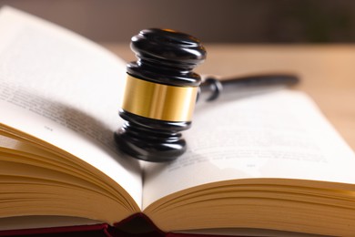 Photo of Judge's gavel on book against blurred background, closeup