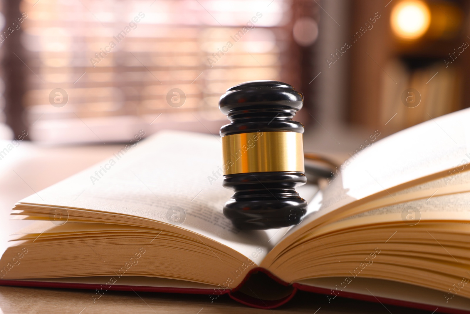 Judge's gavel and book on wooden table indoors, closeup Photo of Judge's gavel and book on wooden table indoors, closeup