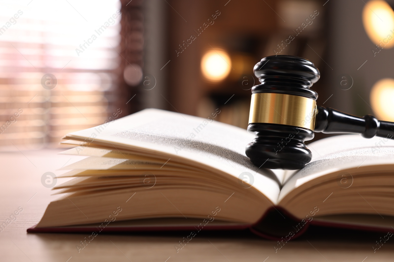 Judge's gavel and book on wooden table indoors, closeup Photo of Judge's gavel and book on wooden table indoors, closeup