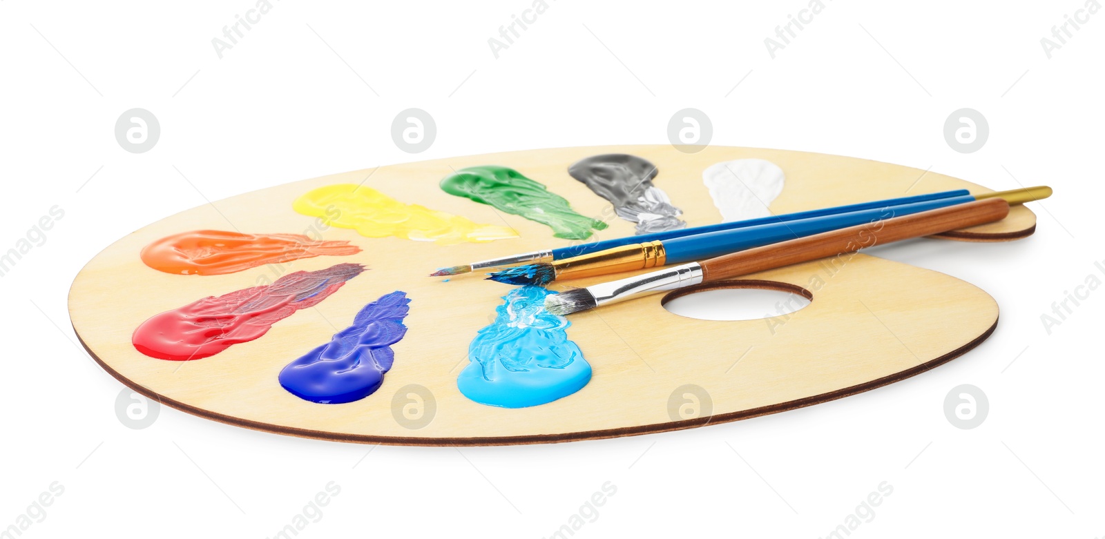 Photo of Wooden palette with paints and brushes isolated on white