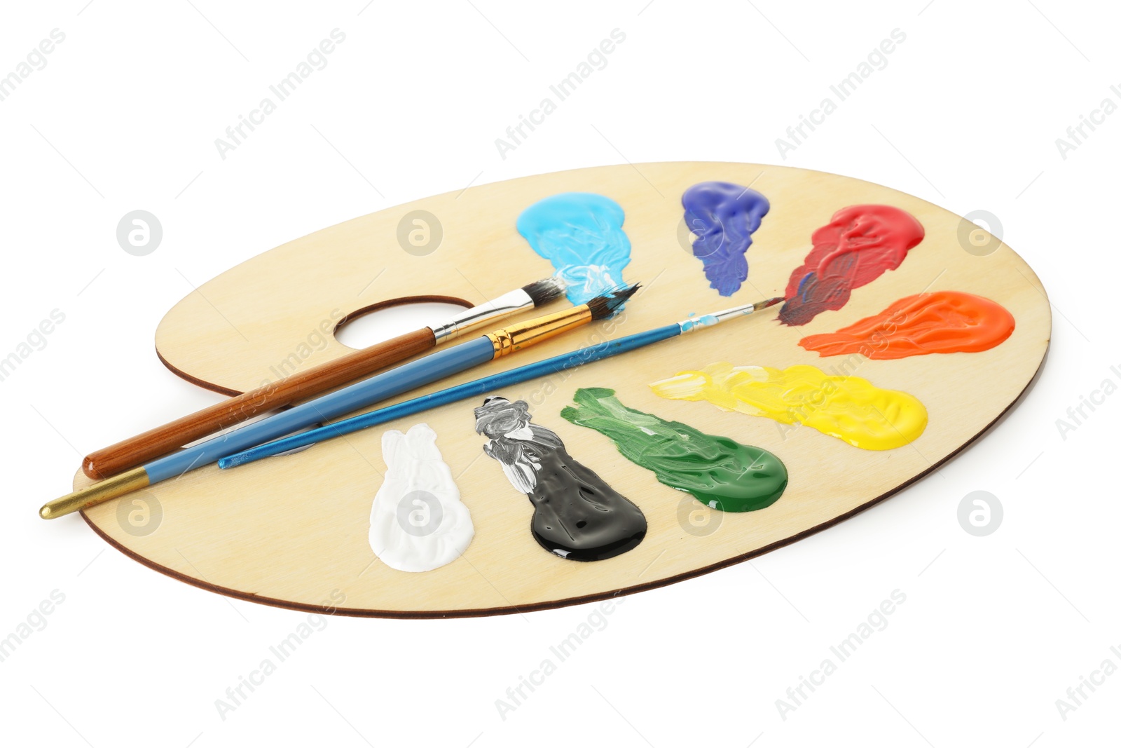 Photo of Wooden palette with paints and brushes isolated on white