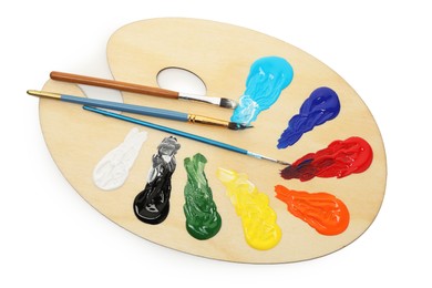 Photo of Wooden palette with paints and brushes isolated on white, top view
