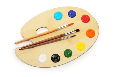 Photo of Wooden palette with paints and brushes isolated on white, top view