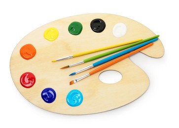 Photo of Wooden palette with paints and brushes isolated on white, top view