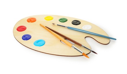 Photo of Wooden palette with paints and brushes isolated on white