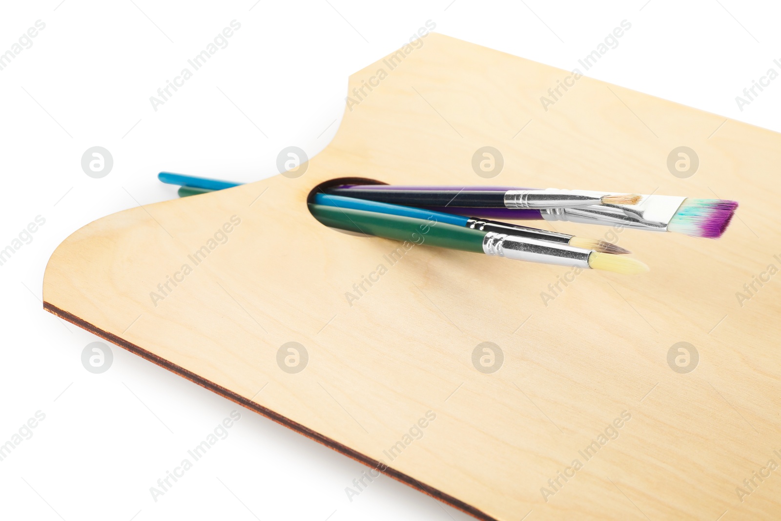 Photo of Wooden palette and brushes isolated on white
