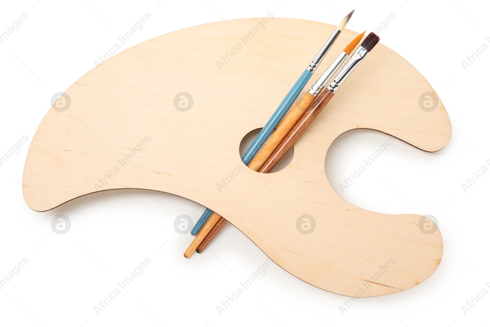 Photo of Wooden palette and brushes isolated on white, top view
