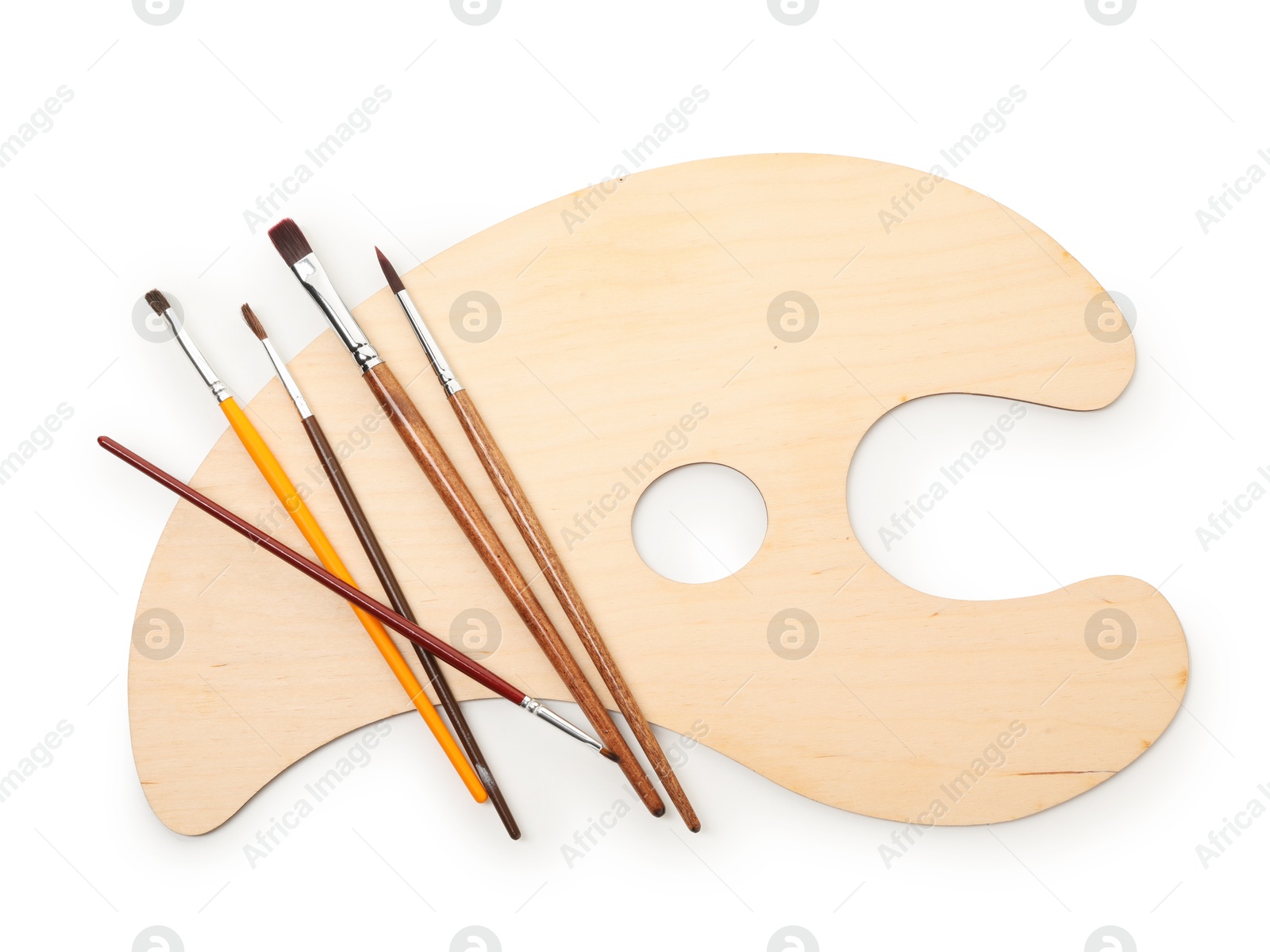 Photo of Wooden palette and brushes isolated on white, top view