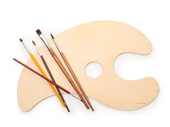Photo of Wooden palette and brushes isolated on white, top view