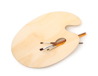 Photo of Wooden palette and brushes isolated on white, top view