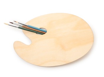 Photo of Wooden palette and brushes isolated on white, top view