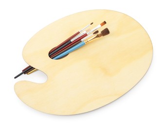 Photo of Wooden palette and brushes isolated on white, top view