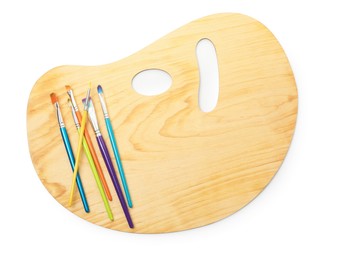 Photo of Wooden palette and brushes isolated on white, top view