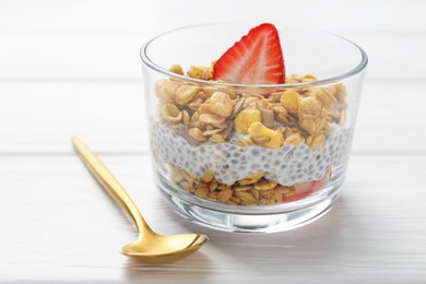 Photo of Delicious dessert with chia seeds, yogurt, granola and strawberries in glass on white wooden table, closeup. Superfood