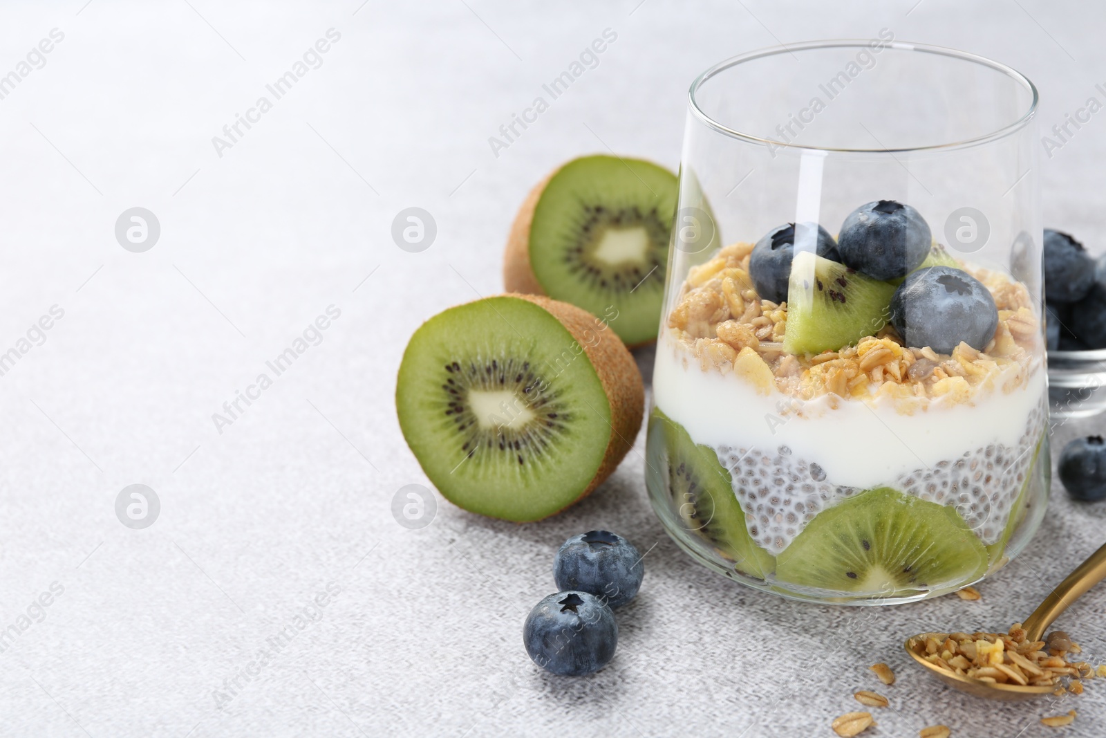 Superfood. Delicious dessert with chia seeds, yogurt, granola, blueberries and kiwi on light grey table, closeup. Space for text Photo of Superfood. Delicious dessert with chia seeds, yogurt, granola, blueberries and kiwi on light grey table, closeup. Space for text