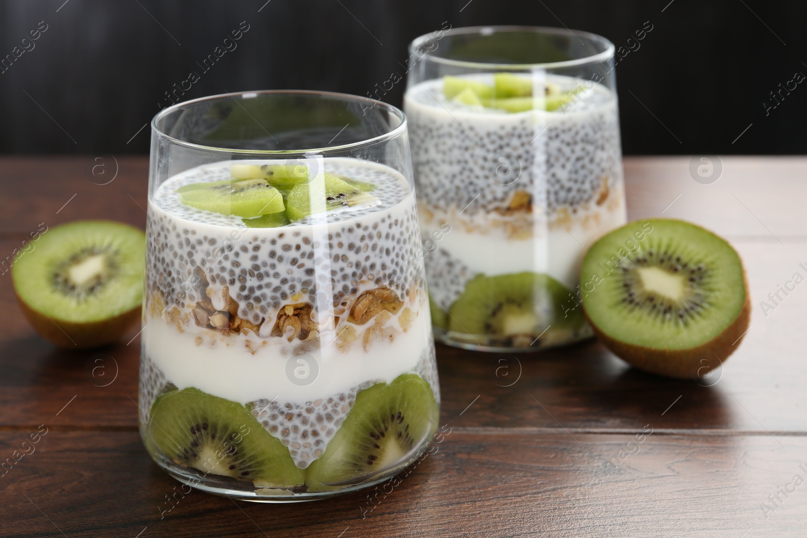 Delicious dessert with chia seeds, yogurt, granola and kiwi on wooden table, closeup. Superfood Photo of Delicious dessert with chia seeds, yogurt, granola and kiwi on wooden table, closeup. Superfood
