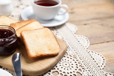 Photo of Slices of tasty toasted bread and jam on wooden table, closeup. Space for text