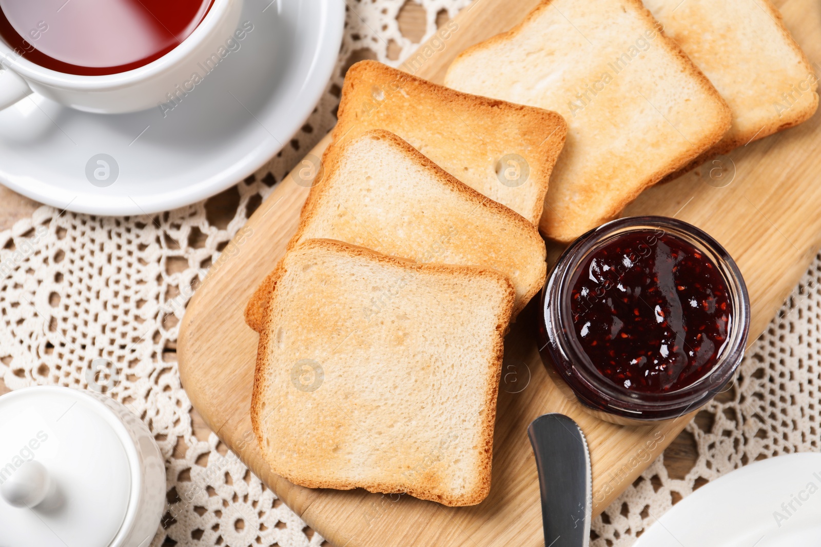 Slices of tasty toasted bread, jam and cup of tea on table, flat lay Photo of Slices of tasty toasted bread, jam and cup of tea on table, flat lay