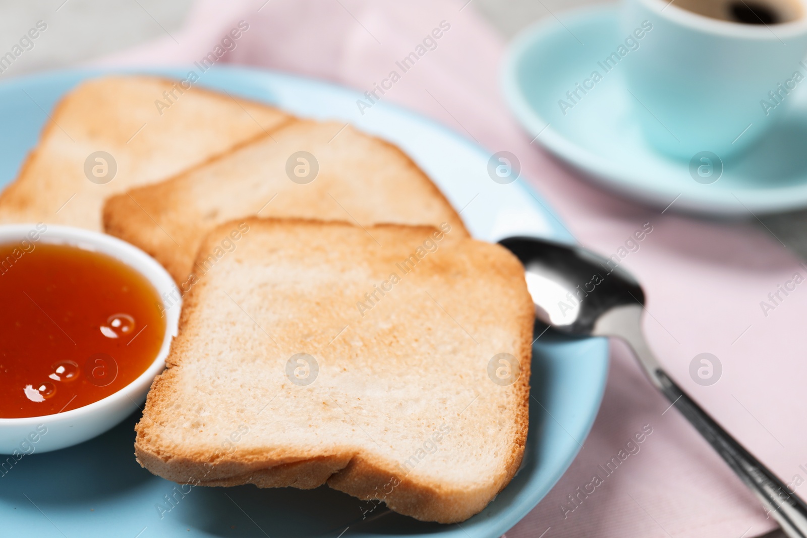 Slices of tasty toasted bread, jam and spoon on pink tablecloth, closeup Photo of Slices of tasty toasted bread, jam and spoon on pink tablecloth, closeup