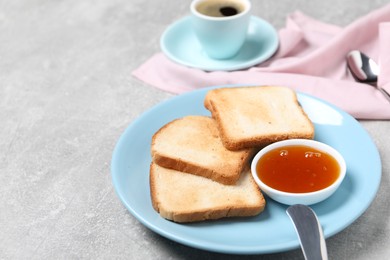 Photo of Slices of tasty toasted bread and jam on grey textured table, closeup. Space for text