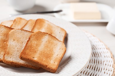 Photo of Slices of tasty toasted bread on white table, closeup