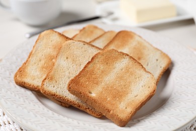 Photo of Slices of tasty toasted bread on white table, closeup
