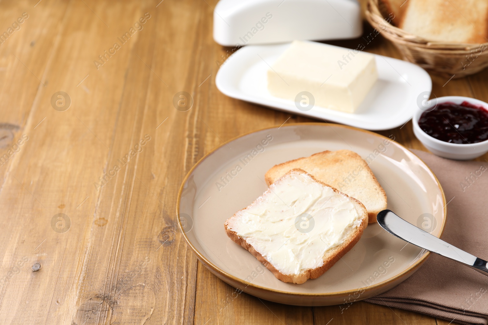 Slices of tasty toasted bread with butter and jam on wooden table, closeup. Space for text Photo of Slices of tasty toasted bread with butter and jam on wooden table, closeup. Space for text
