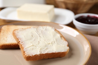 Photo of Slices of tasty toasted bread with butter on table, closeup