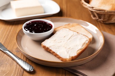Photo of Slices of tasty toasted bread with butter and jam on wooden table, closeup