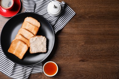 Photo of Slices of tasty toasted bread with butter and jam on wooden table, flat lay. Space for text