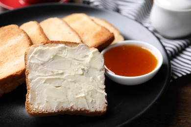 Photo of Slices of tasty toasted bread with butter and jam on table, closeup