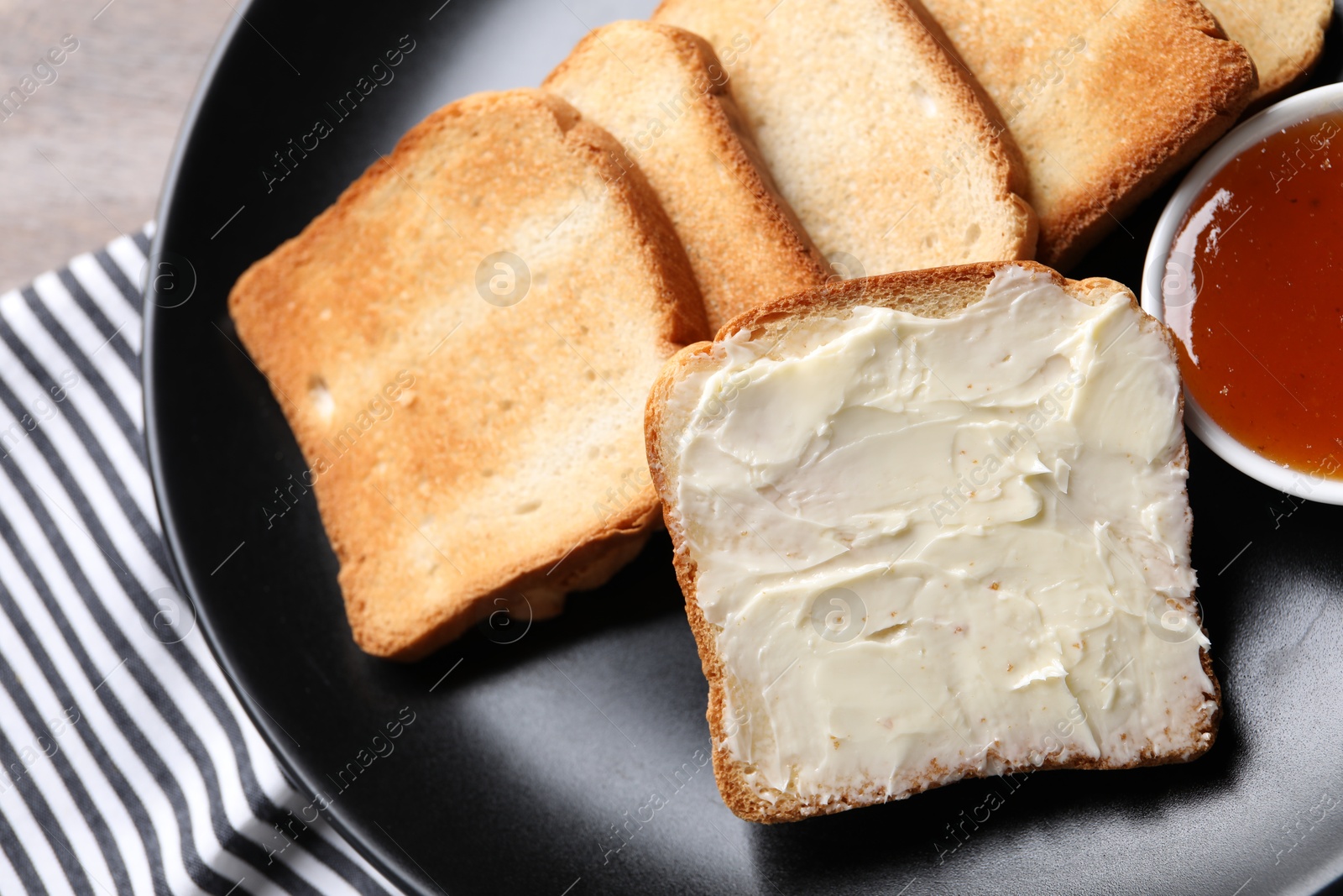 Slices of tasty toasted bread with butter and jam on table, top view Photo of Slices of tasty toasted bread with butter and jam on table, top view