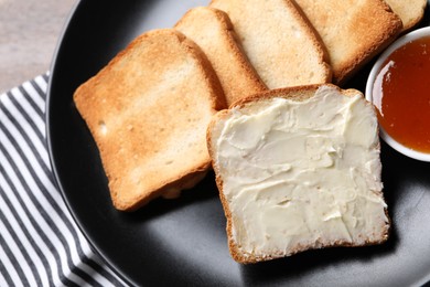 Photo of Slices of tasty toasted bread with butter and jam on table, top view